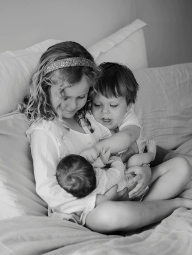 big-sister-cuddling-baby-sibling Big sister and big brother cuddling new sibling